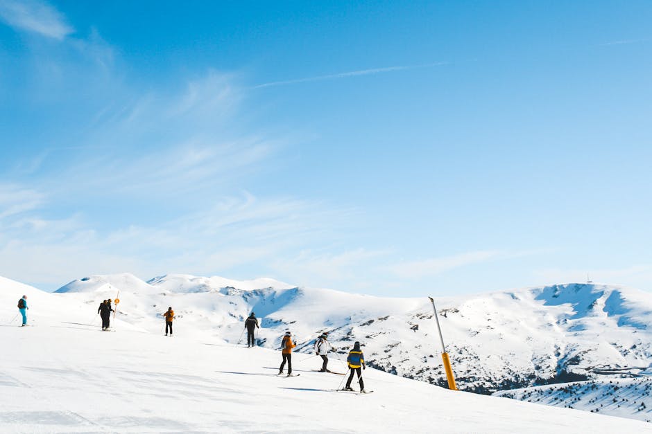 Esquiadores disfrutando de un día soleado en pistas de esquí de montaña