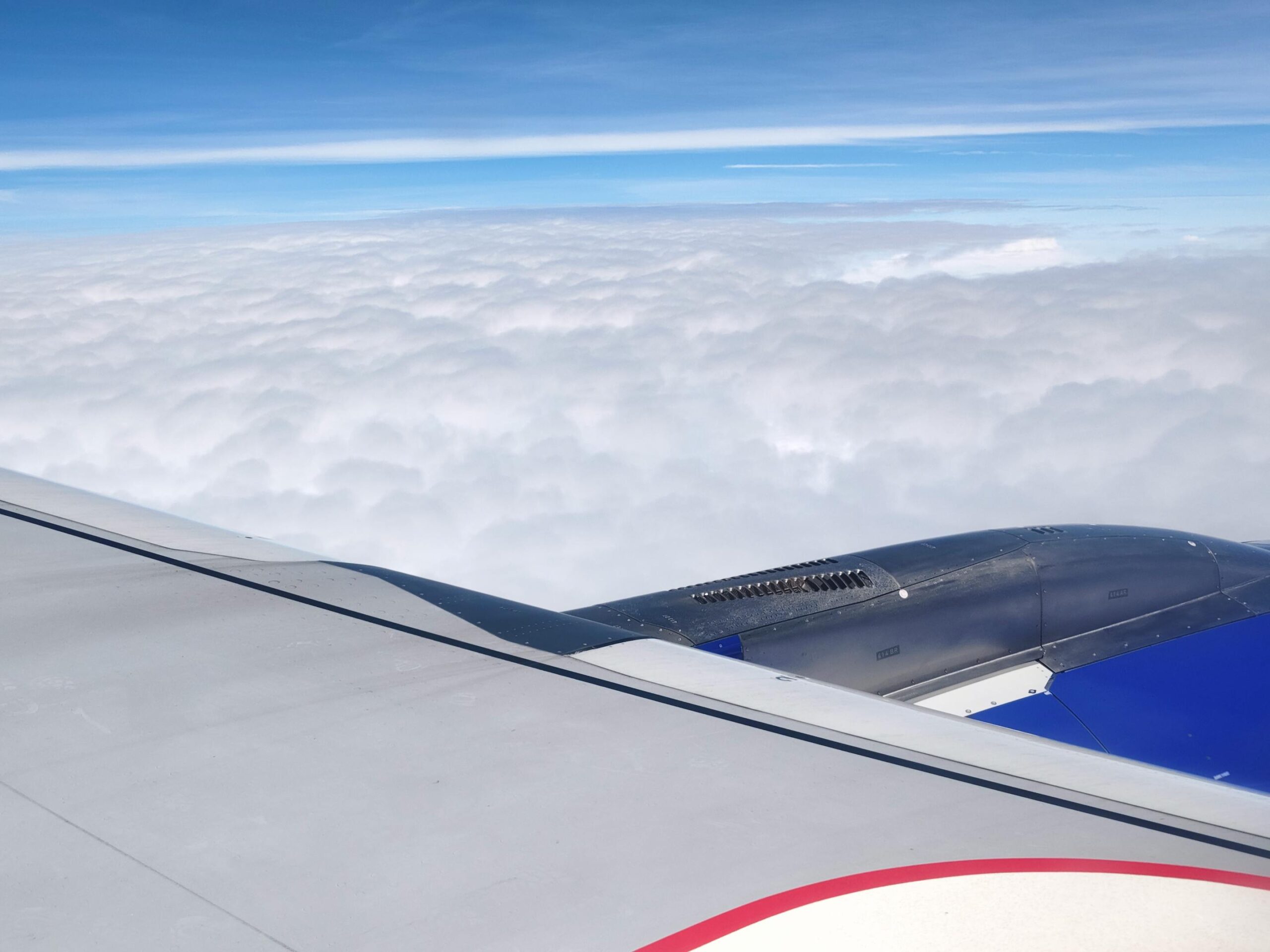 Ala de avion volando sobre el oceano Atlantico entre nubes