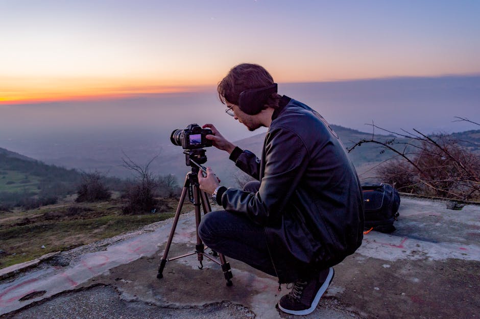 Fotografo capturando un atardecer sobre un paisaje de colinas