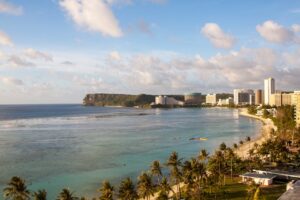 Vista aérea de la costa de Guam con playa tropical y arquitectura moderna