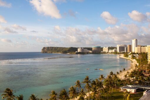 Vista aérea de la costa de Guam con playa tropical y arquitectura moderna