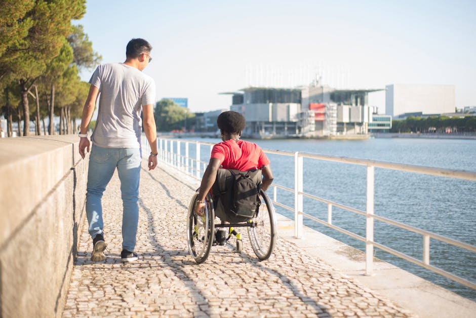 Turismo accesible en 2026: guía completa de recursos para viajar sin barreras 2 Dos amigos, uno en silla de ruedas, paseando junto al río disfrutando del turismo accesible