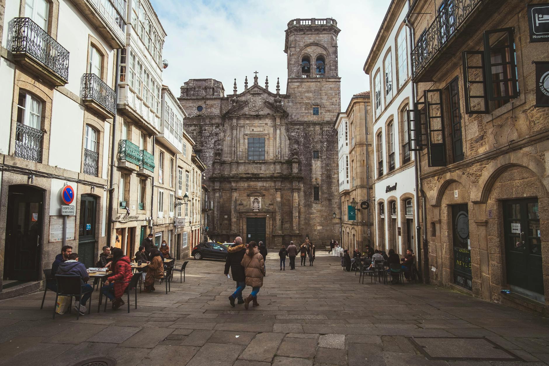 Plaza medieval animada de Santiago de Compostela con peregrinos y viajeros