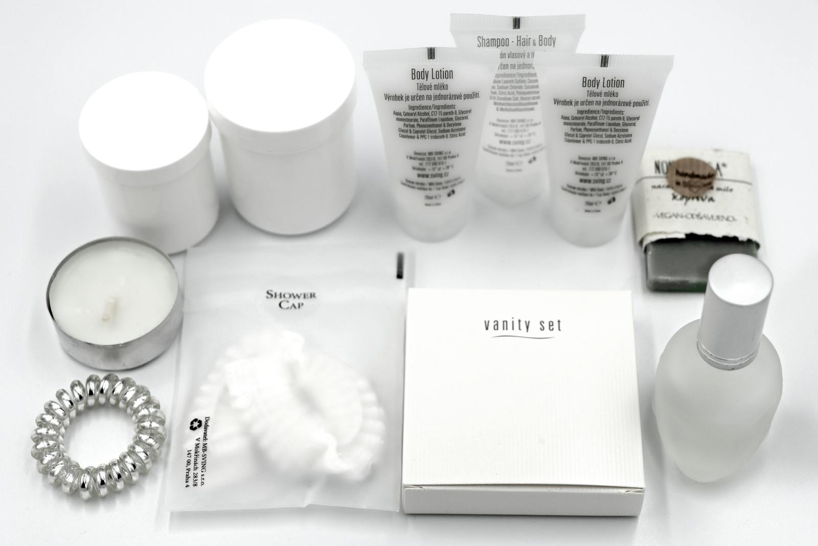 Neceser de viaje con productos de aseo y amenities de hotel en flat lay