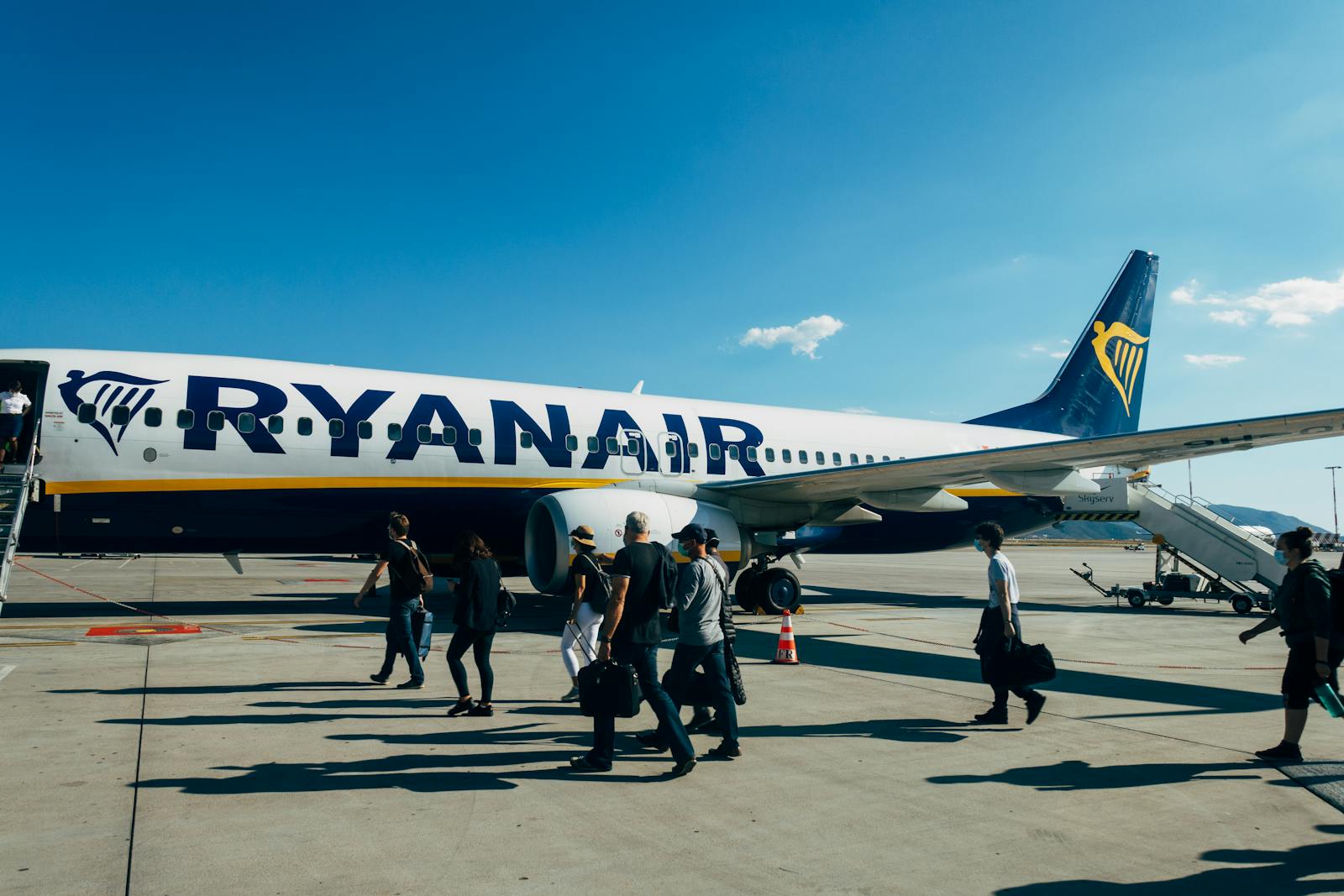 Pasajeros embarcando en un avion de Ryanair en un aeropuerto soleado