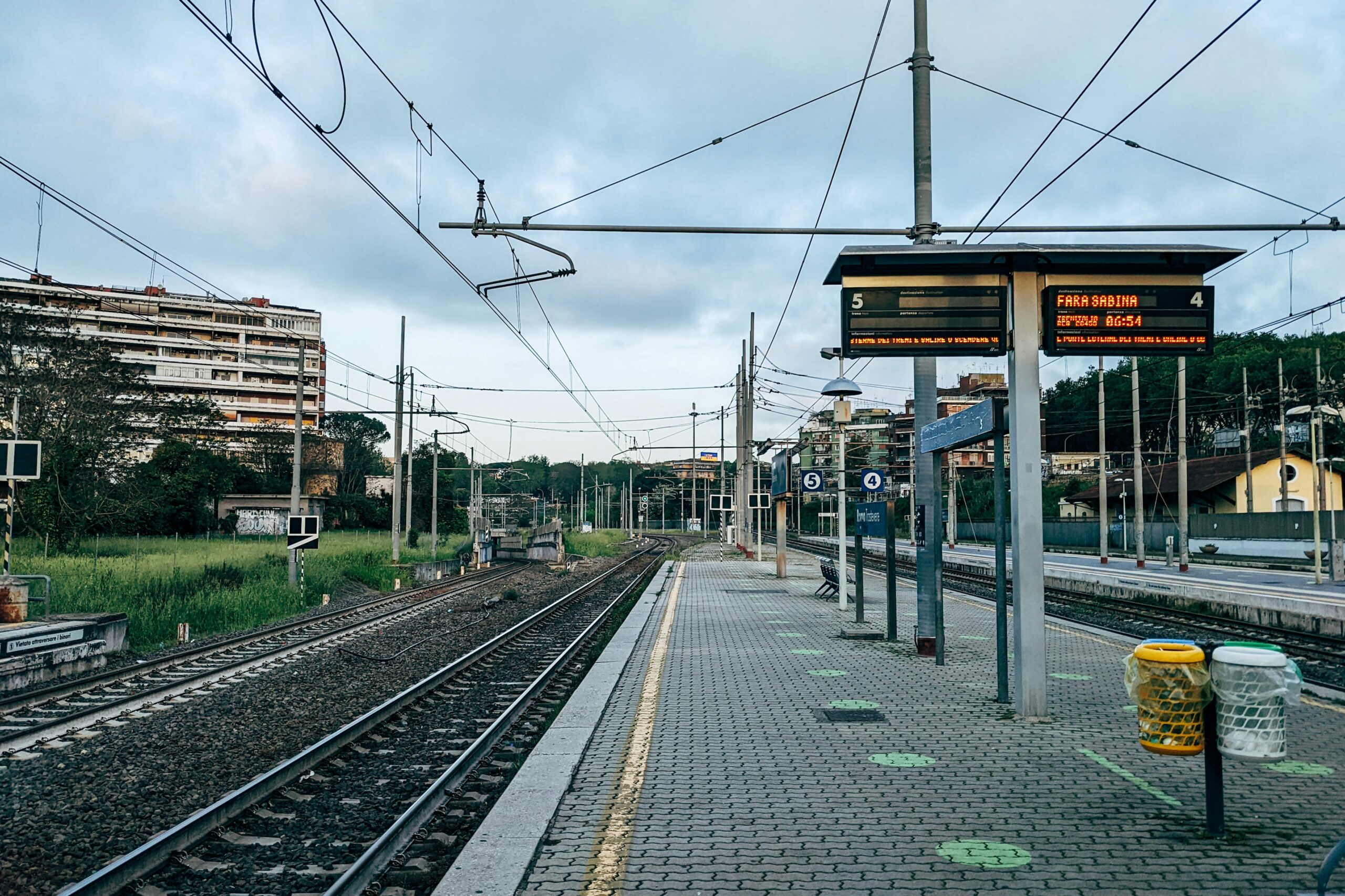 Anden vacio de estacion de tren en Roma al amanecer con vias