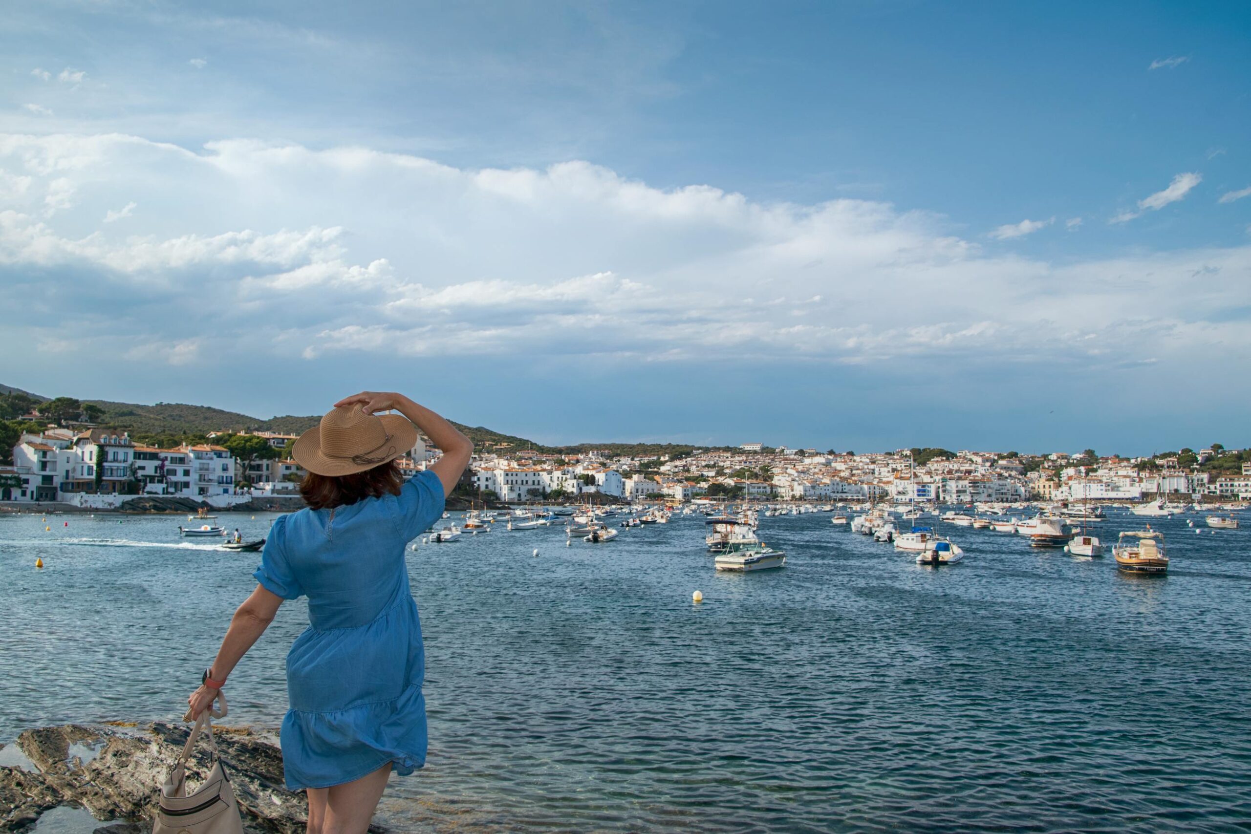 Mujer contemplando las vistas del mar y las barcas de Cadaques