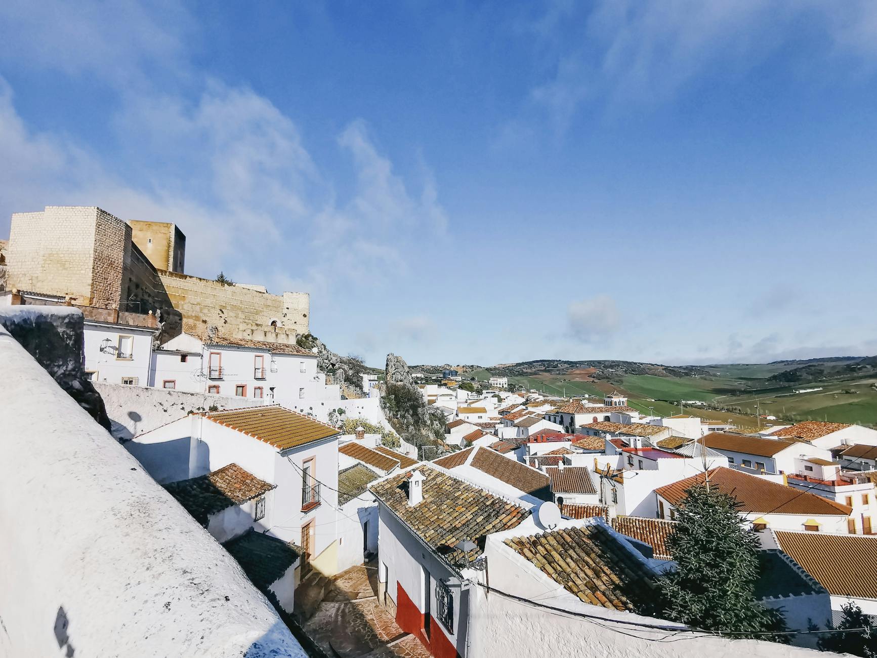 Vista panorámica de pueblo español con casas blancas y castillo histórico en Andalucía, similar a Belmez (Córdoba)