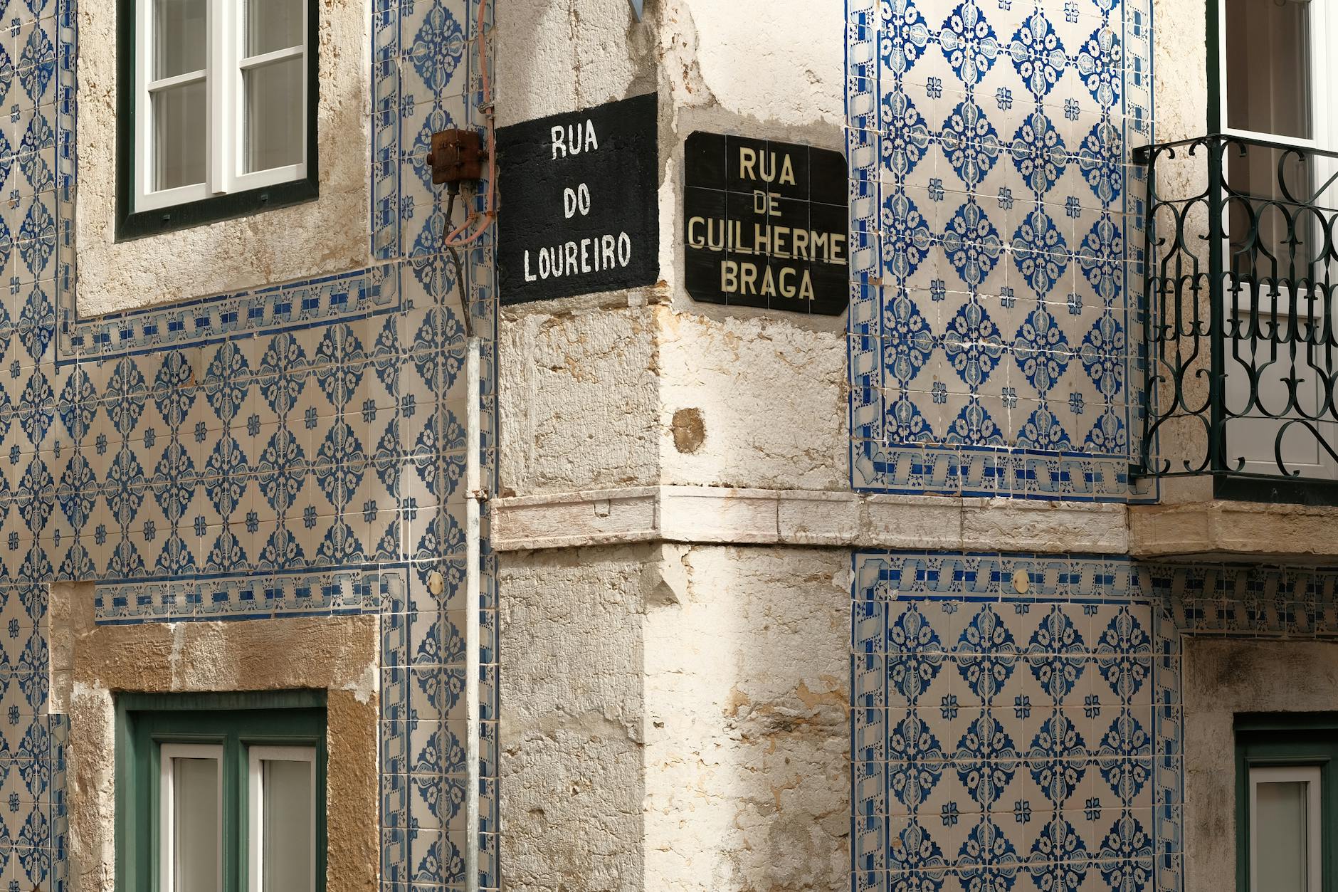 Fachada tradicional de Lisboa cubierta de azulejos azules con los nombres de la calle