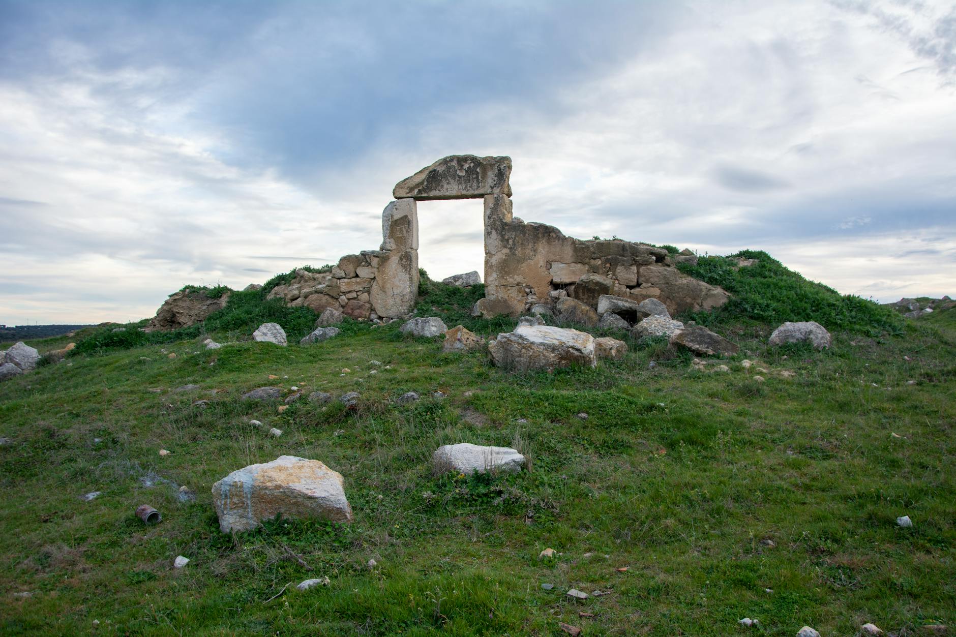 Antigua estructura de piedra nurágica sobre colina herbosa en Cerdeña