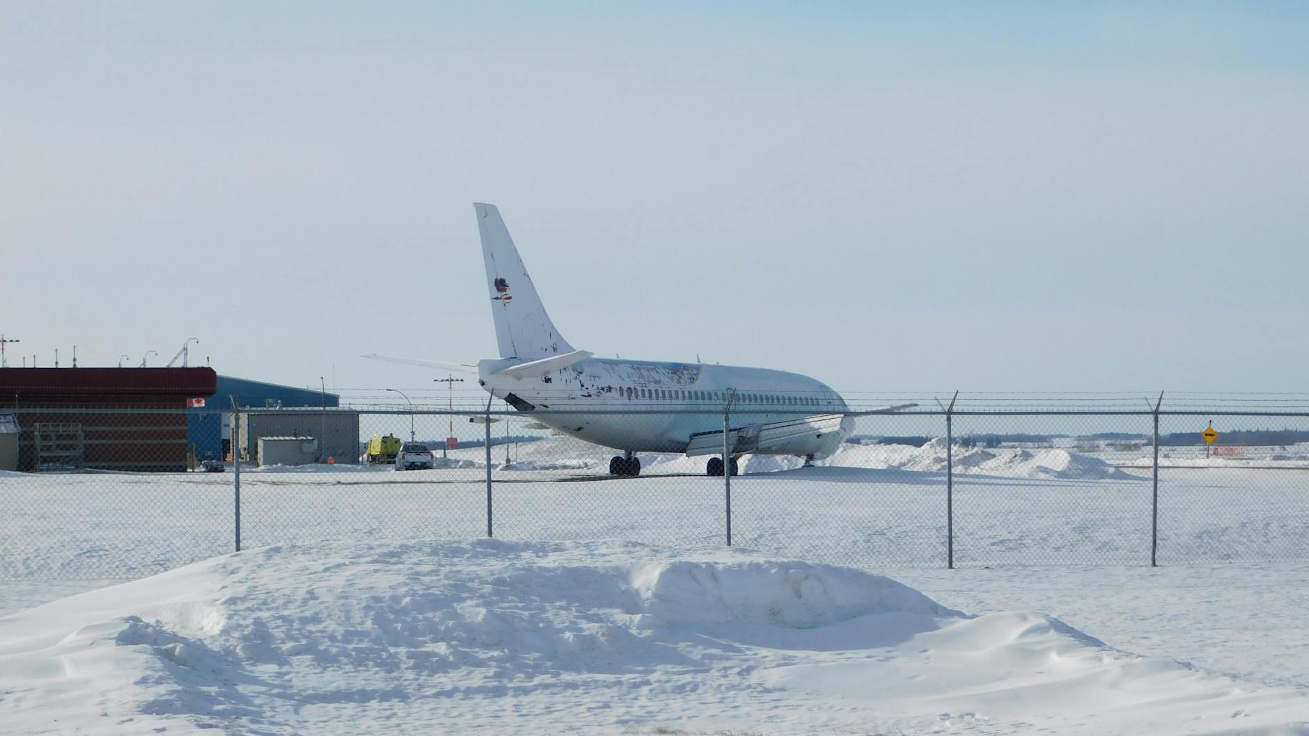 Avion estacionado en pista nevada de aeropuerto en temporada baja invernal