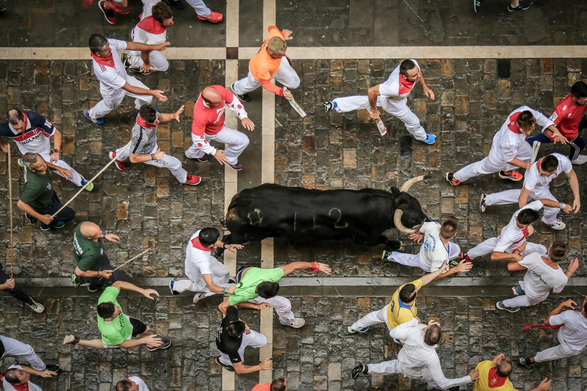 Vista aerea de participantes corriendo delante de un toro durante los Sanfermines de Pamplona
