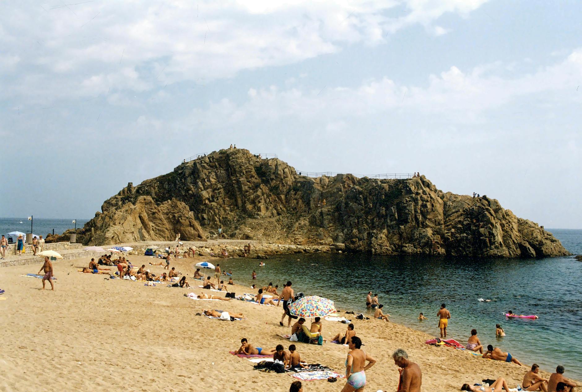 Playa masificada en Blanes con turistas disfrutando del sol en la Costa Brava