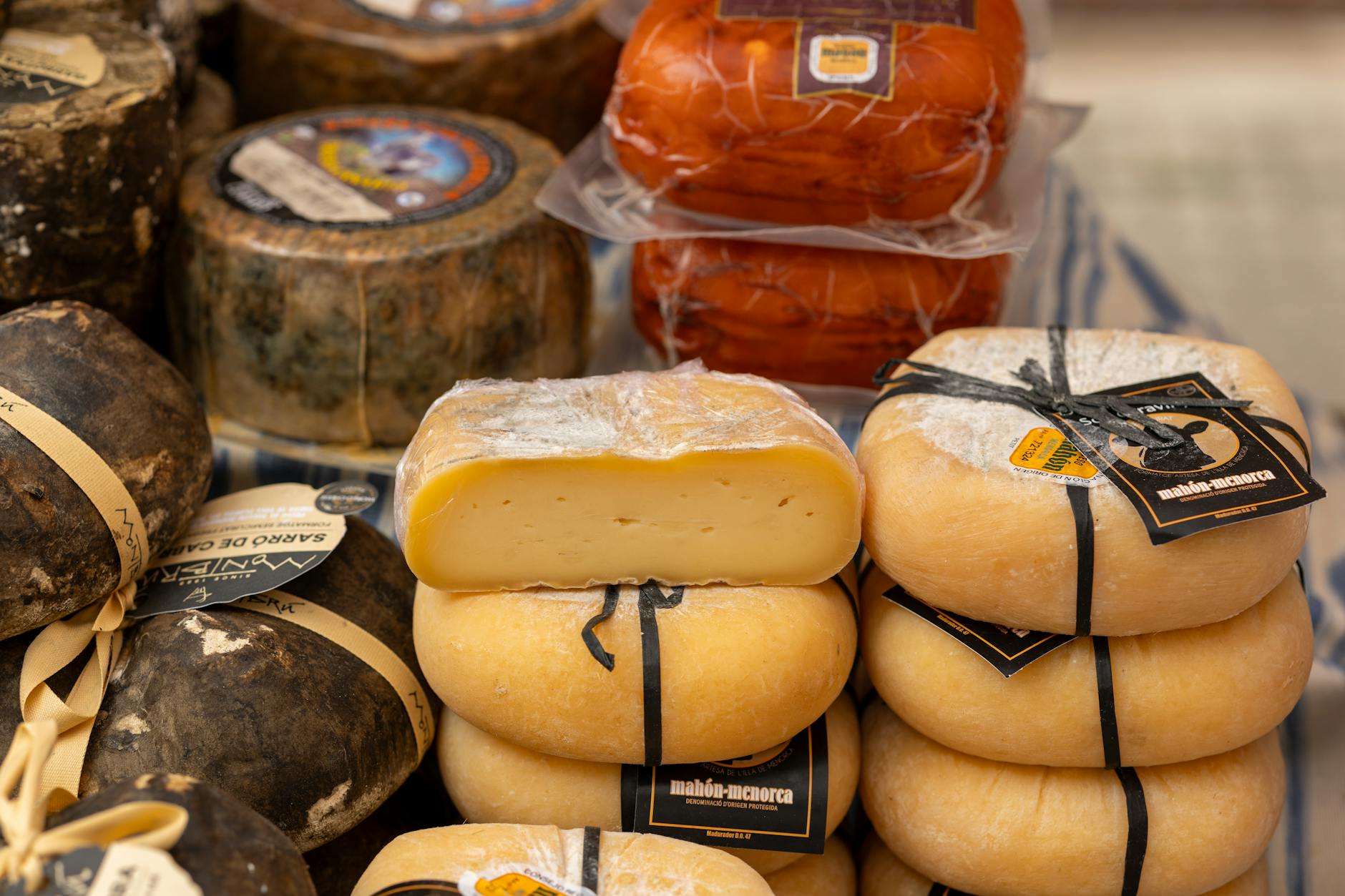 Quesos manchegos tradicionales expuestos en un mostrador de mercado en Espana