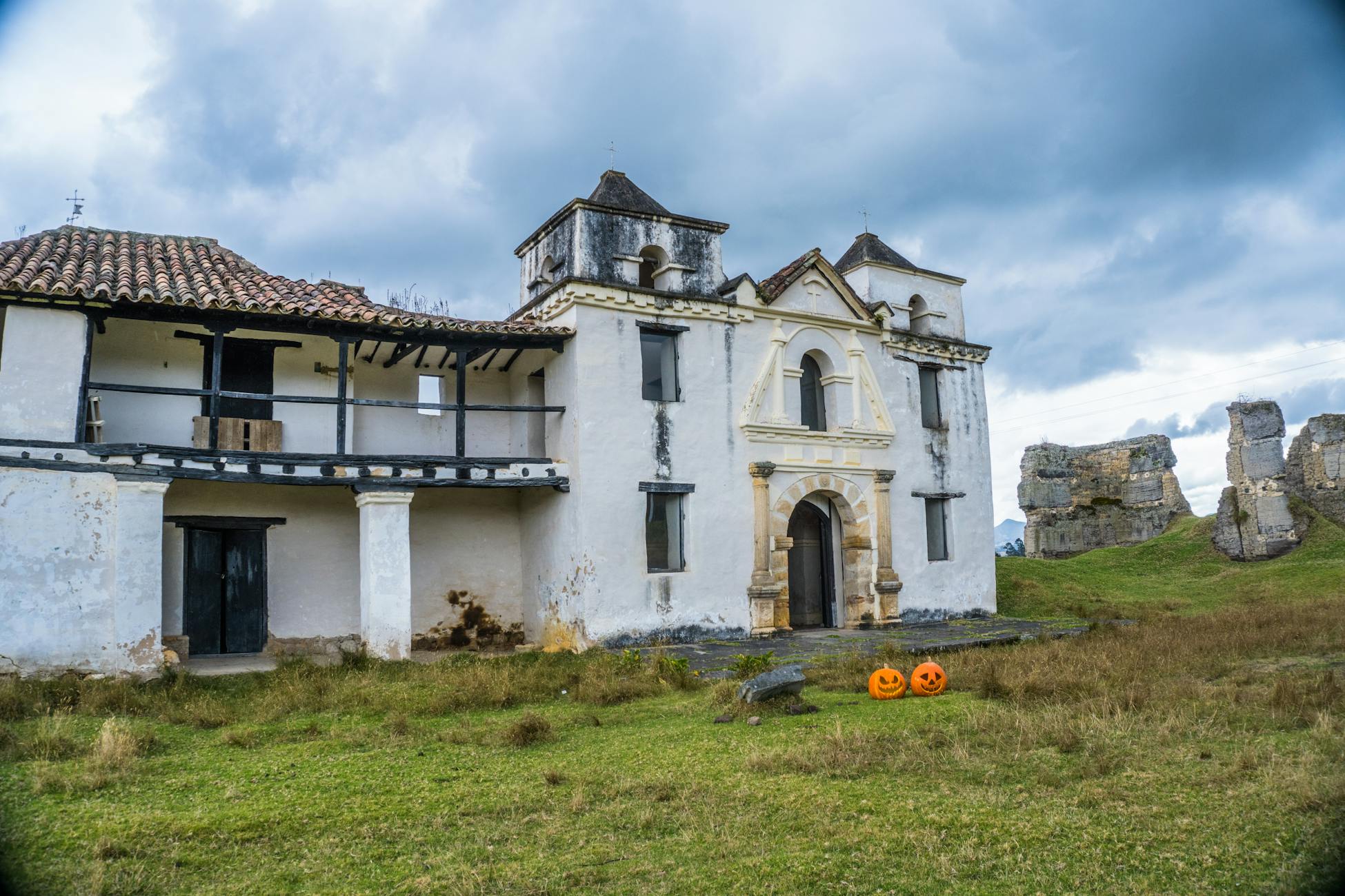 Casa rural antigua decorada al estilo Halloween con calabazas en la entrada