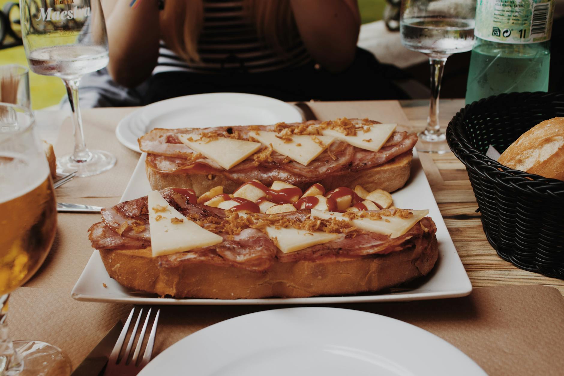 Tostas españolas típicas con jamón, queso y guarnición servidas en restaurante, representando la gastronomía de interior de España
