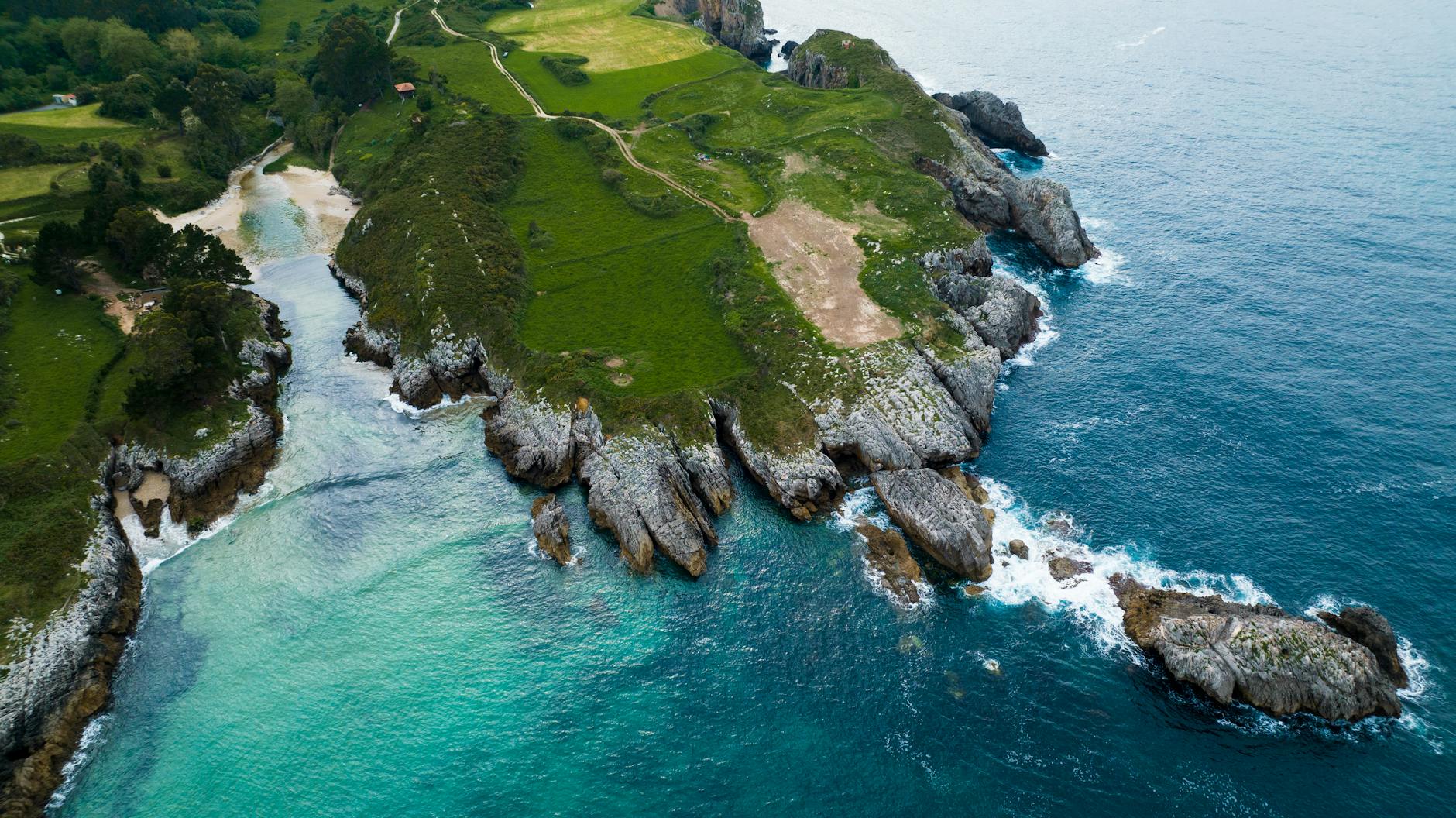 Acantilados y costa rocosa del norte de España en Cantabria, con vegetación exuberante y mar azul
