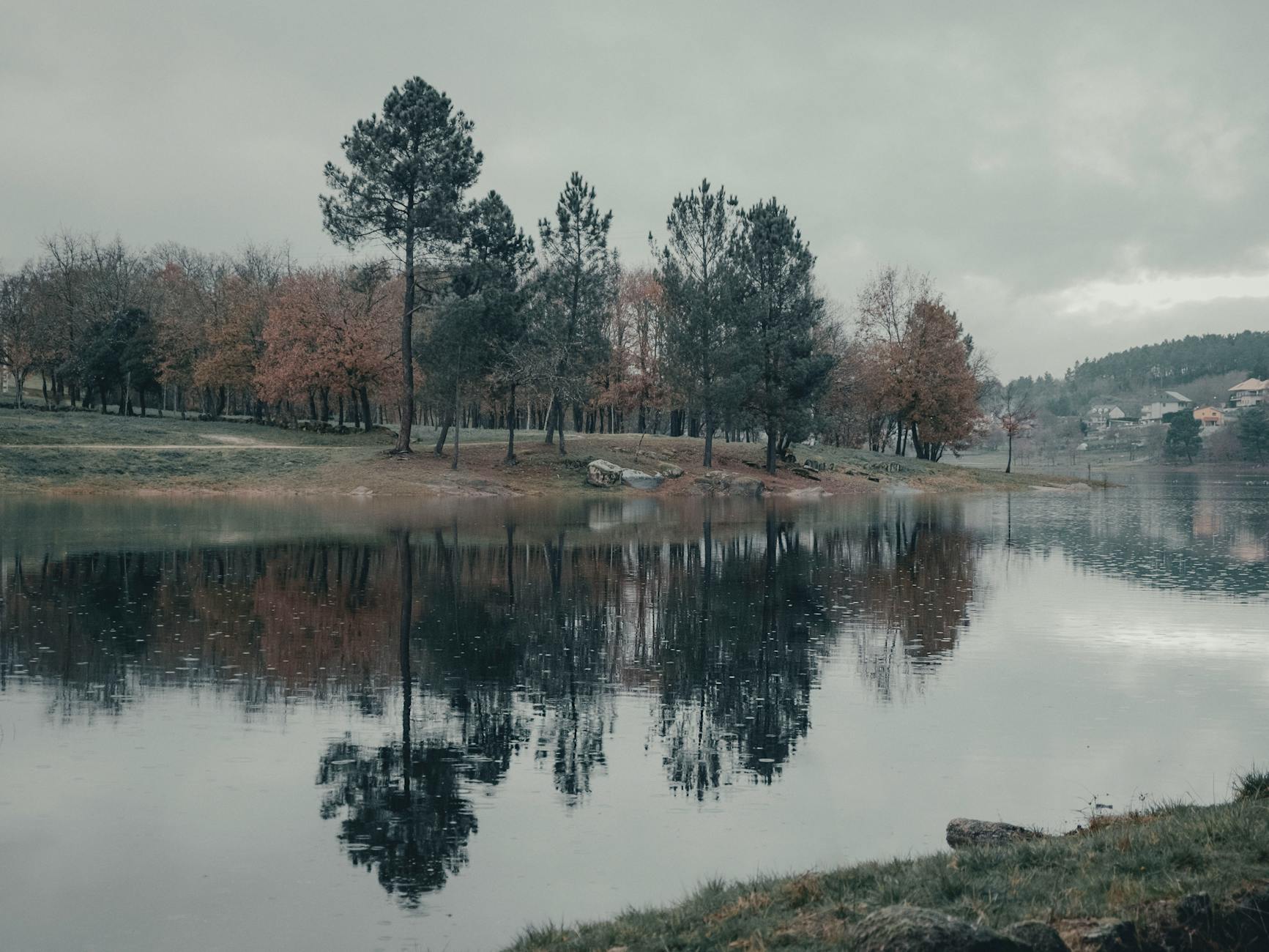 Paisaje otonal tranquilo con arboles reflejados en el embalse de Cachamuina Ourense