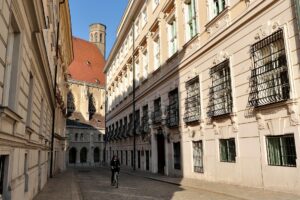 Calle estrecha del centro de Viena con edificios historicos y un ciclista