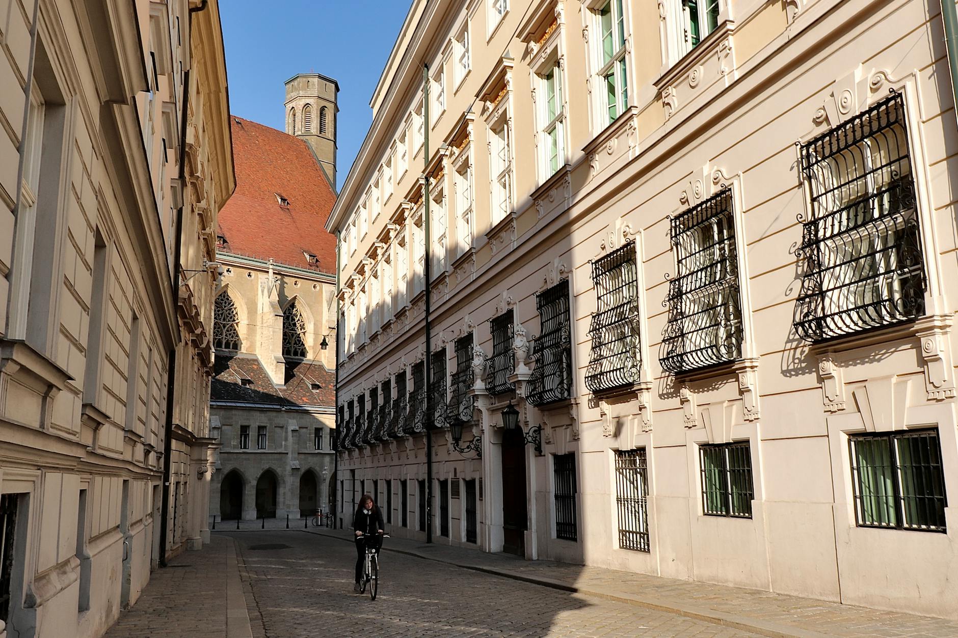 Calle estrecha del centro de Viena con edificios historicos y un ciclista