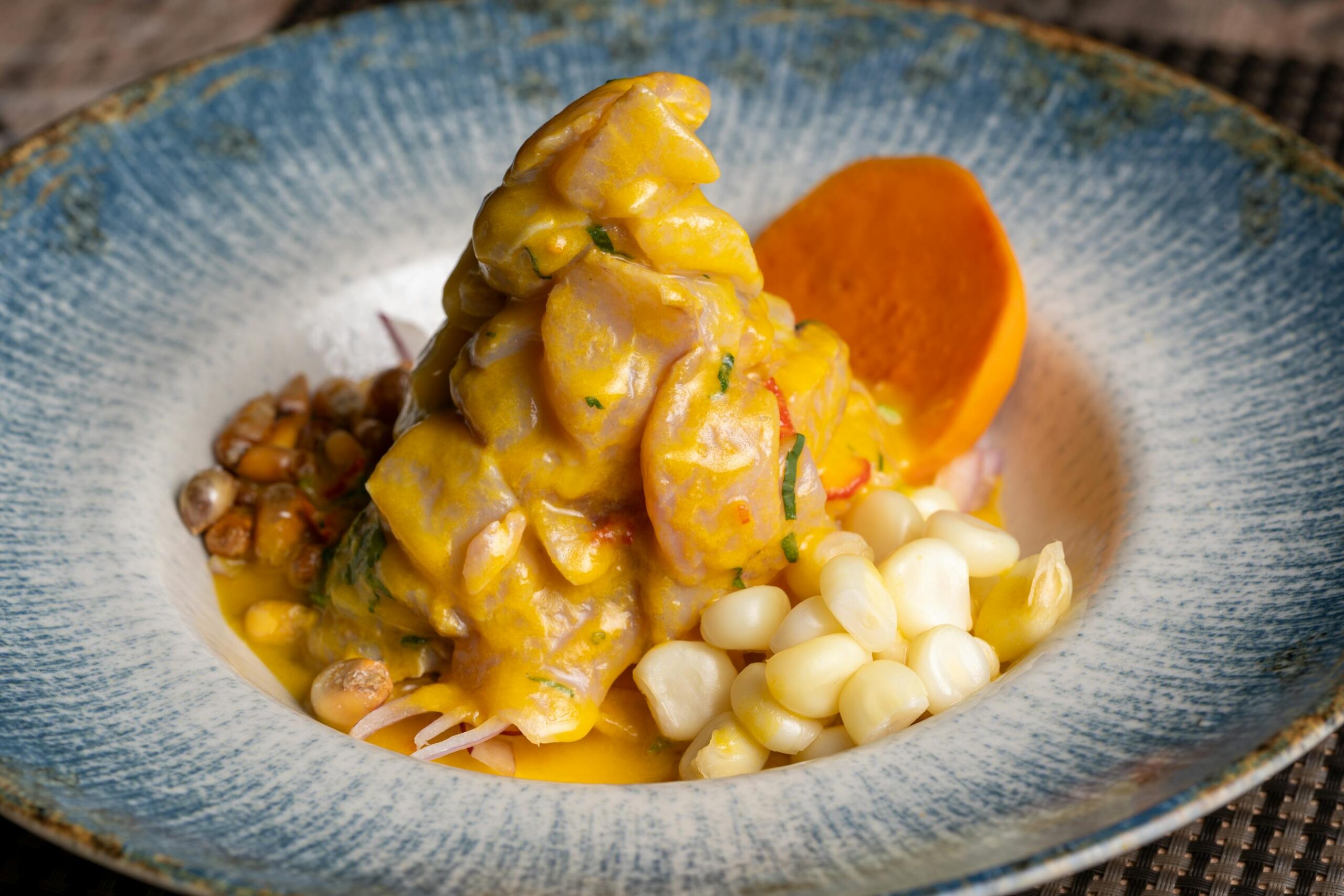 Plato de ceviche peruano con pescado fresco maiz cancha y boniato sobre ceramica decorada