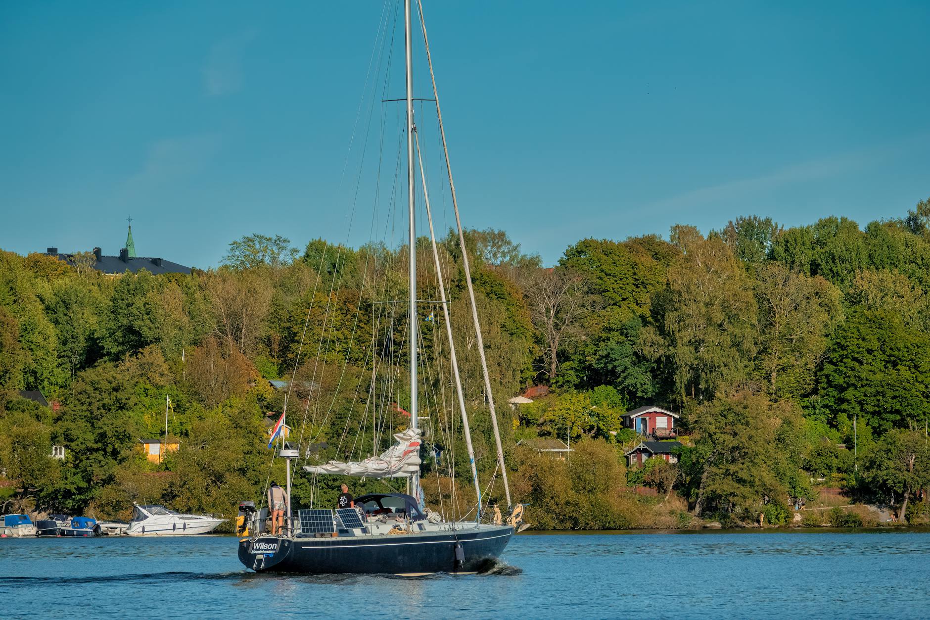 Velero navegando en aguas tranquilas rodeado de naturaleza verde en el archipielago de Estocolmo Suecia