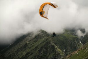 Parapente sobrevolando las montañas verdes de Linhares en la Serra da Estrela, Portugal