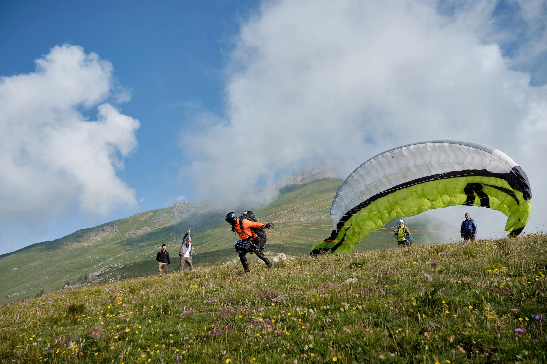 Despegue de parapente desde la cima de una montana con vistas al valle