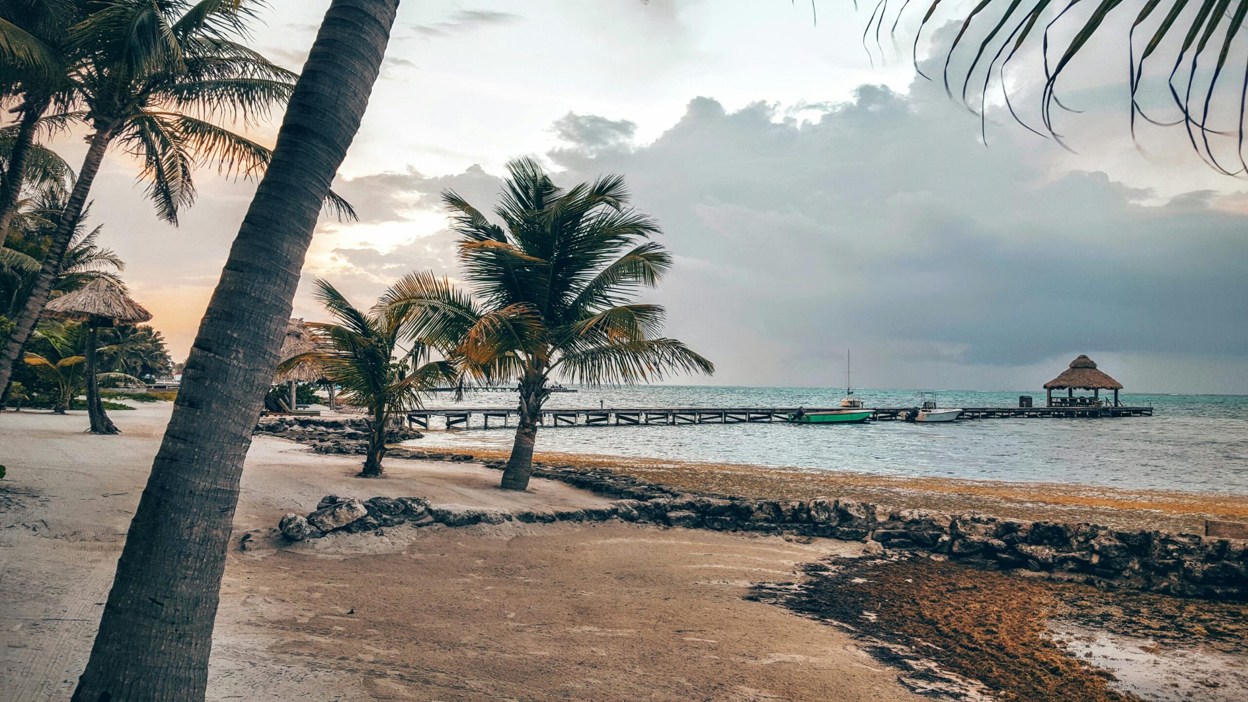 Belice 2026: guía honesta para viajar al secreto del Caribe maya 3 Atardecer en un muelle de madera con palmeras en San Pedro, Belice