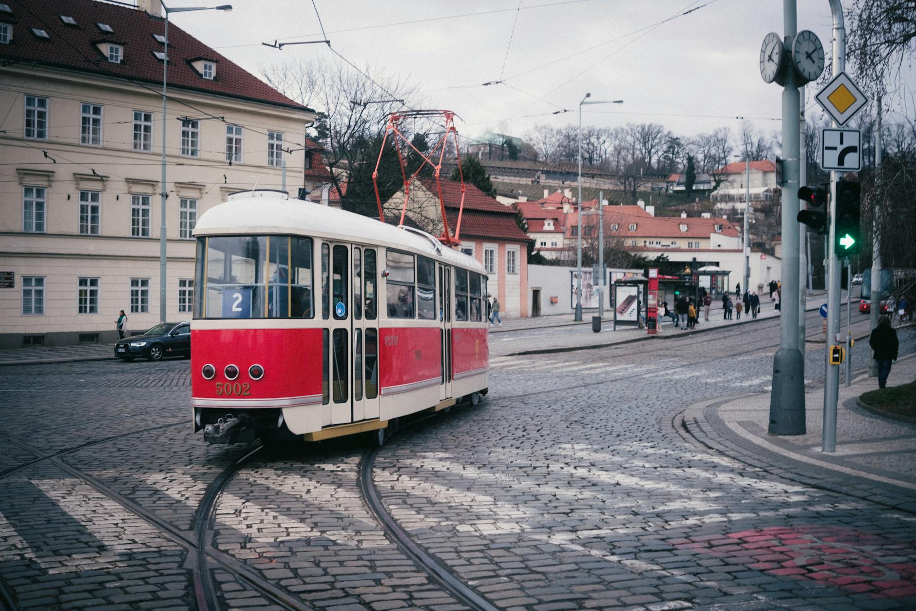 Tranvia rojo de Praga circulando por una calle empedrada del centro historico