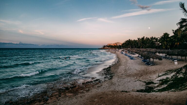 Atardecer en la playa de Varadero con palmeras y olas tranquilas, Cuba