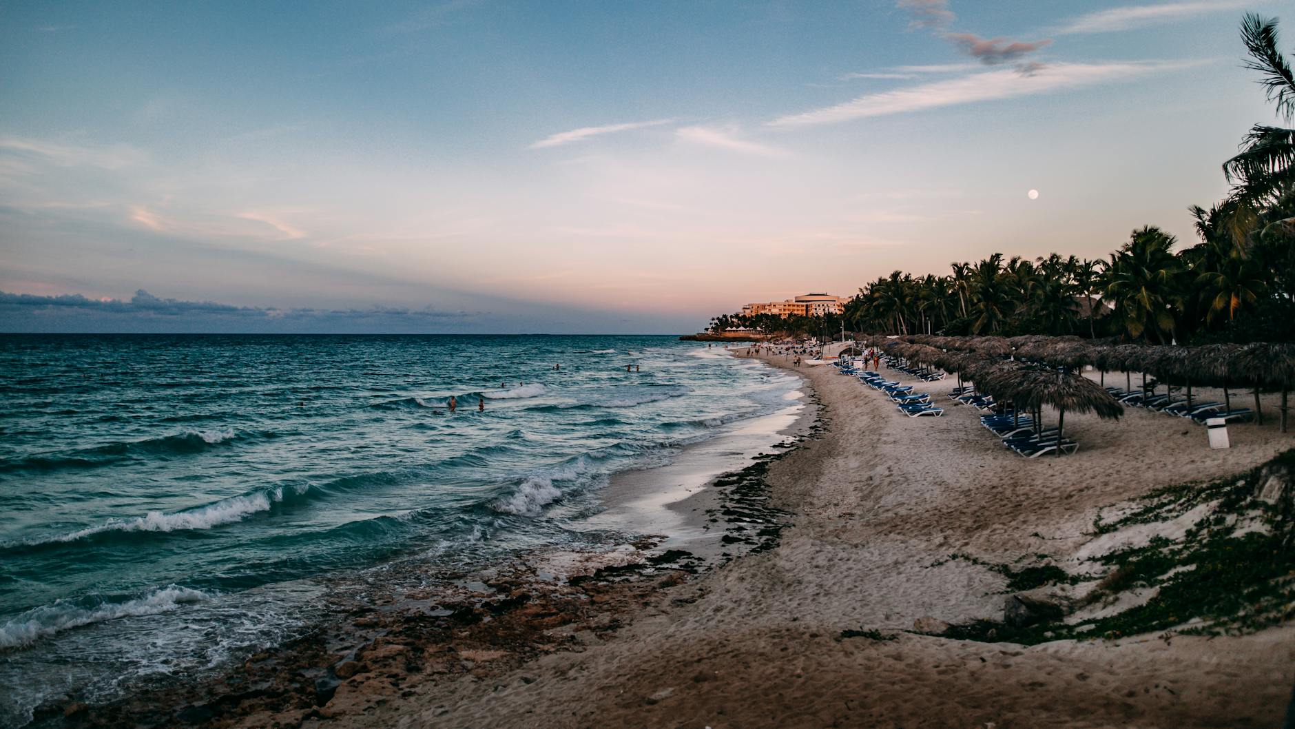 Atardecer en la playa de Varadero con palmeras y olas tranquilas, Cuba