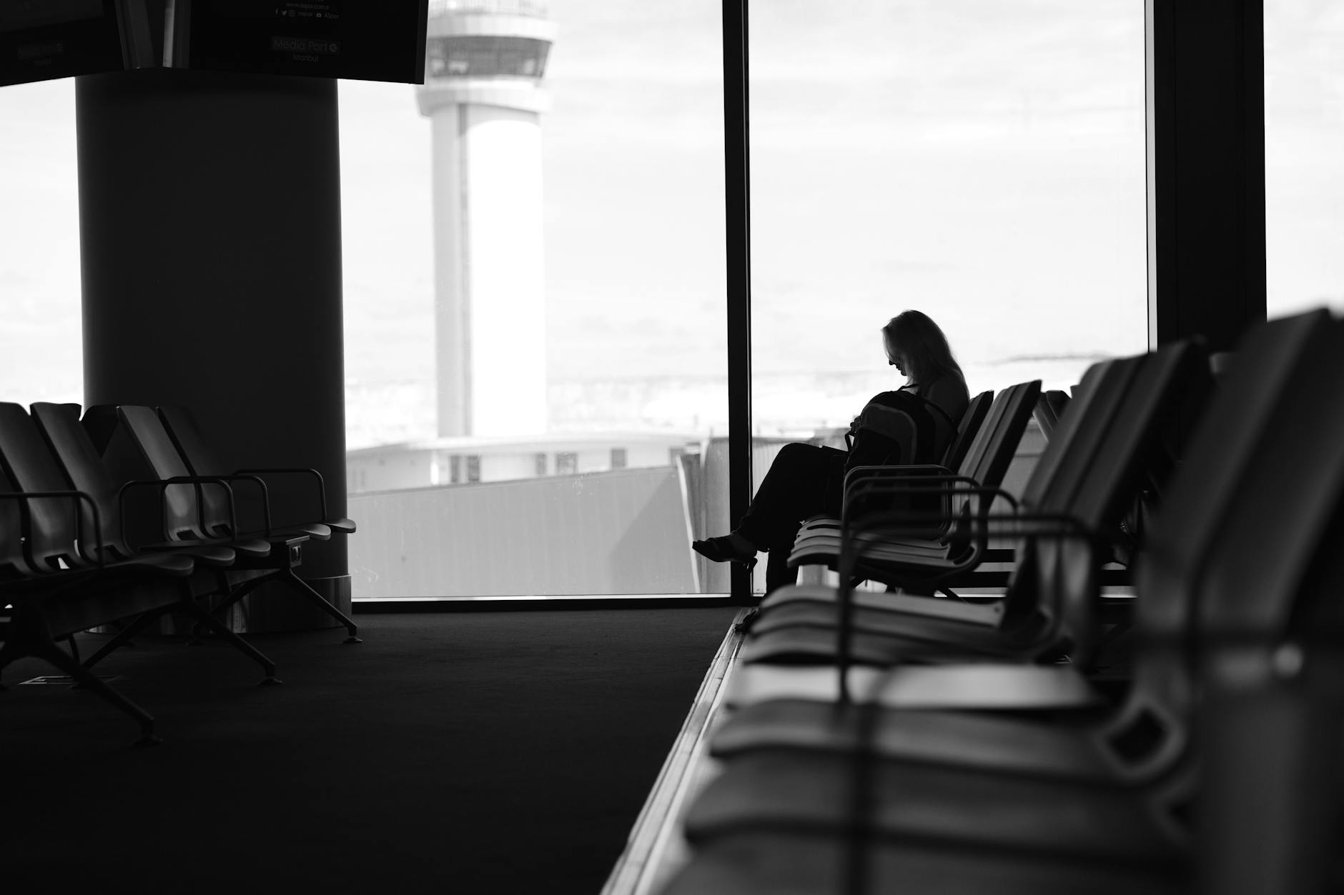 Pasajero usando el movil en el aeropuerto para gestionar la reserva de su vuelo