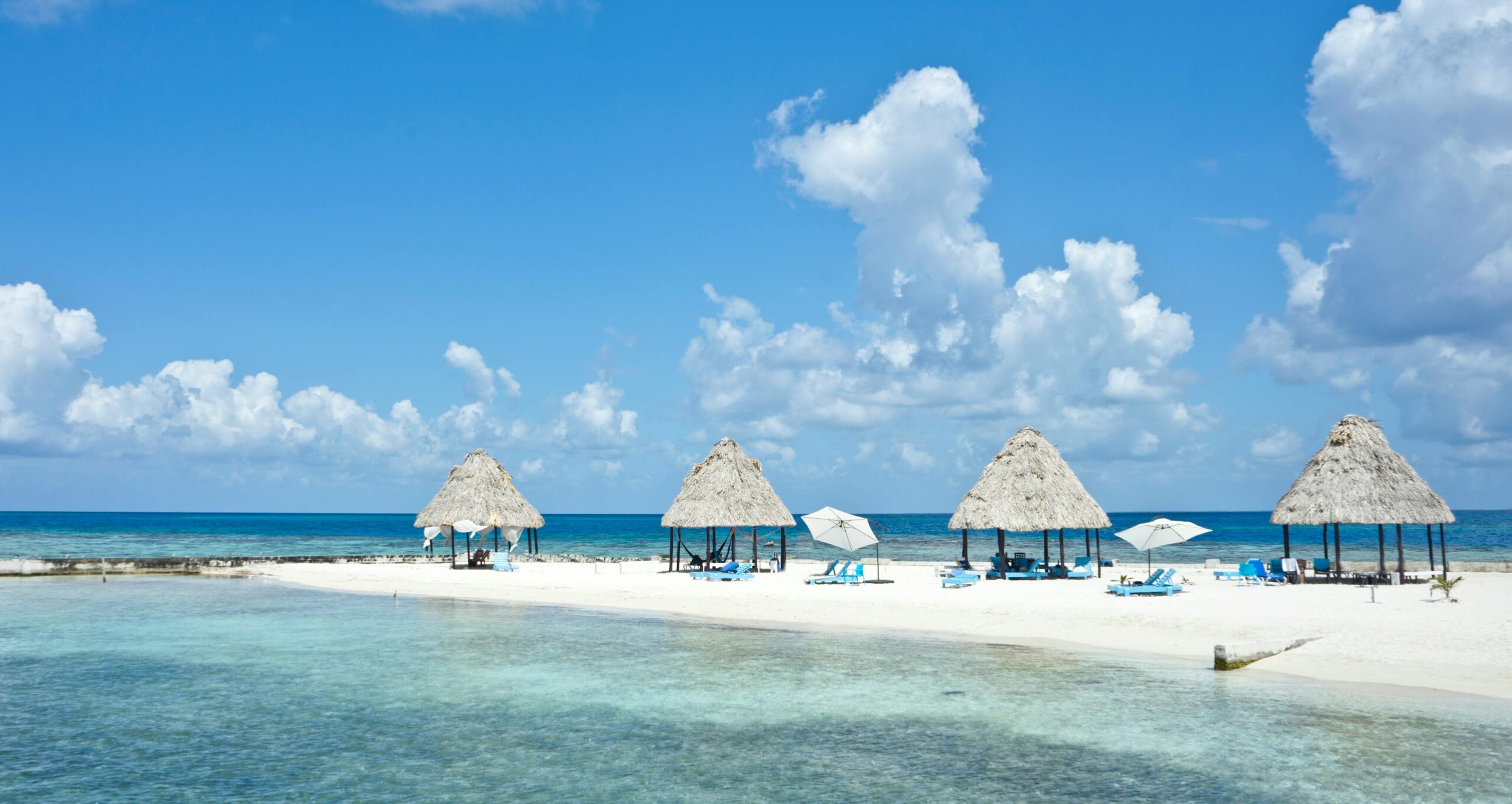 Belice 2026: guía honesta para viajar al secreto del Caribe maya 6 Playa tropical con palapas en un dia soleado en Belice