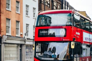 Autobus rojo de dos pisos circulando por una calle de Londres