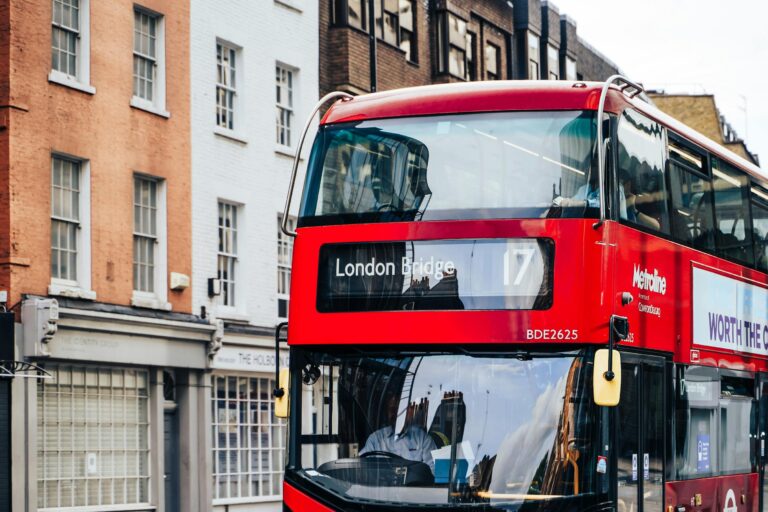 Autobus rojo de dos pisos circulando por una calle de Londres