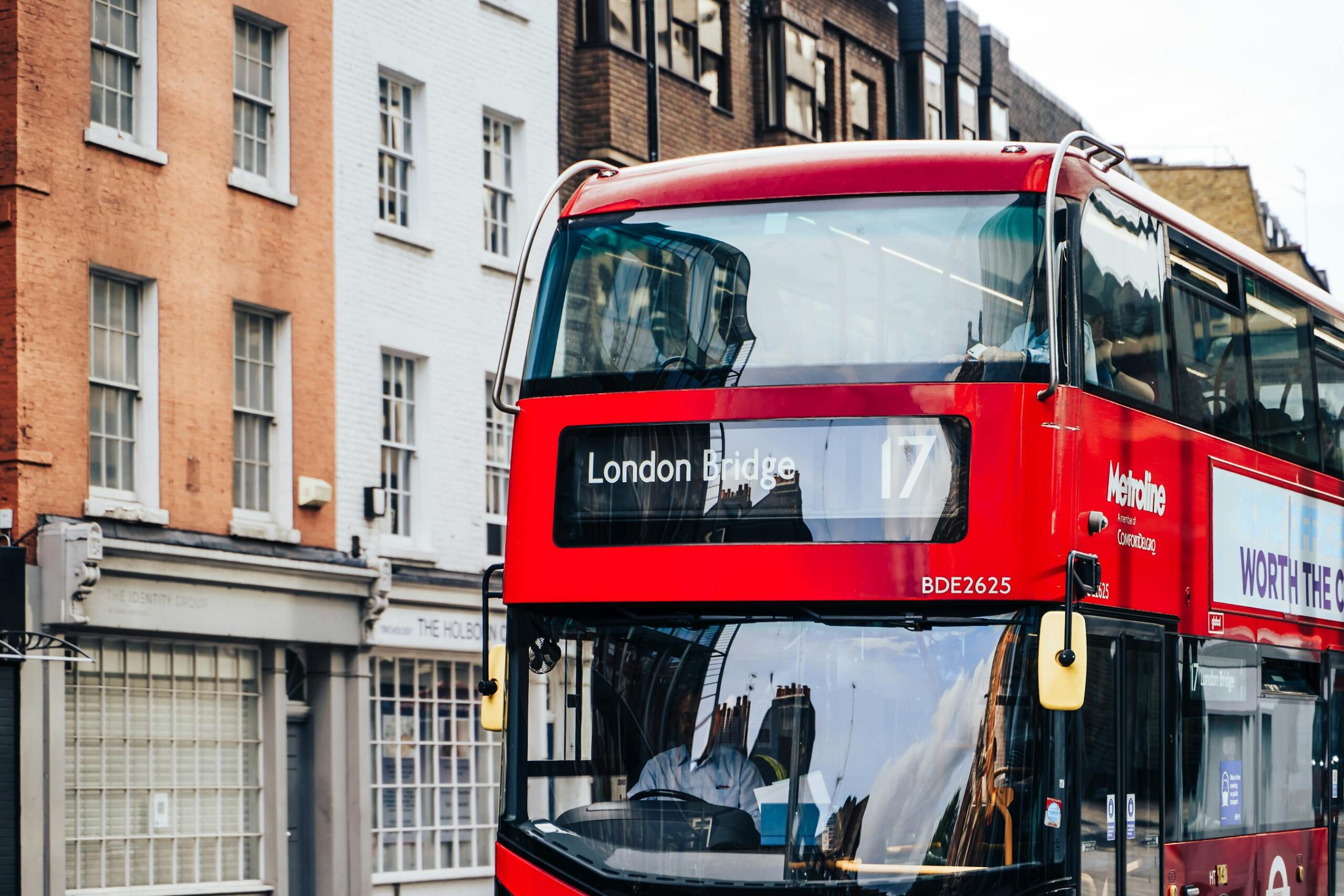 Autobus rojo de dos pisos circulando por una calle de Londres