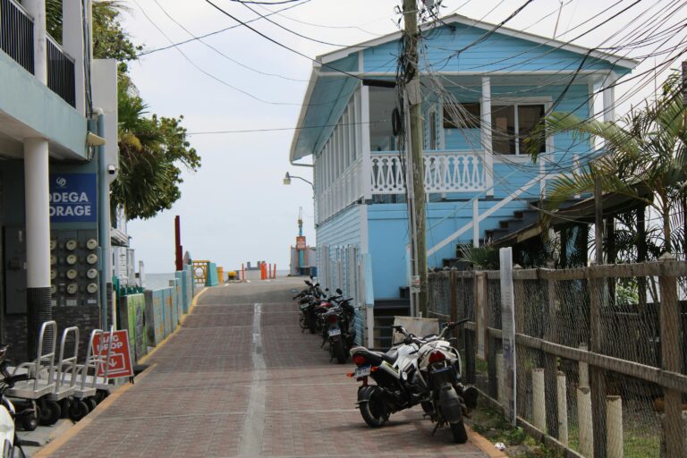 Calle de Utila con casa azul y motos aparcadas, isla de Honduras en el Caribe