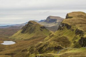 Paisaje típico de la Isla de Skye con montañas verdes, lago y nubes bajas en las Highlands escocesas