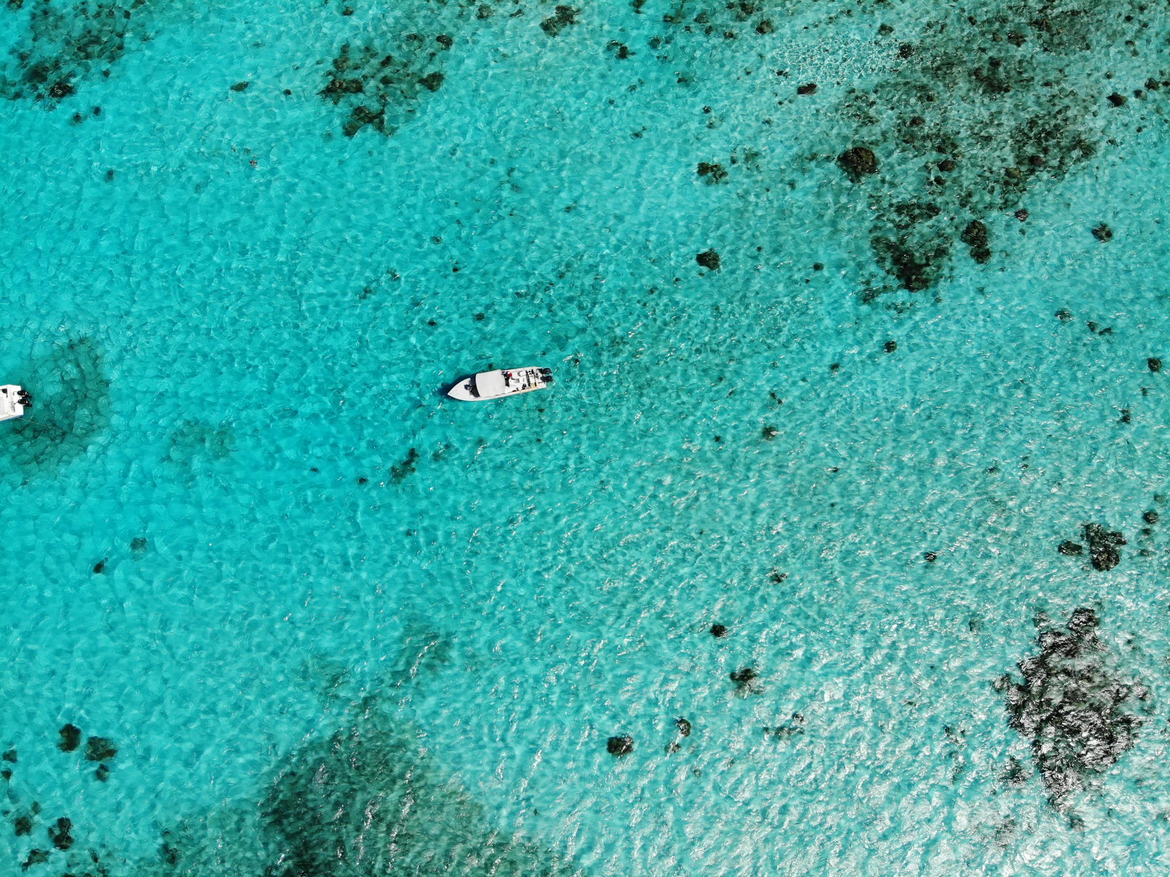 Belice 2026: guía honesta para viajar al secreto del Caribe maya 1 Vista aerea de embarcaciones blancas sobre las aguas turquesas de Belice