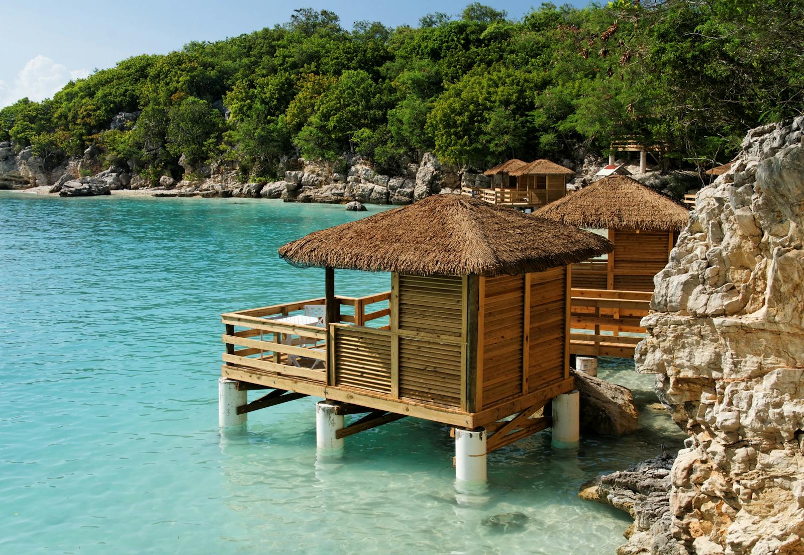 Puerto Príncipe en 2026: guía honesta de la capital de Haití (y por qué hoy no se viaja) 2 Cabañas de palafito con techo de paja sobre aguas turquesas en la costa de Haití