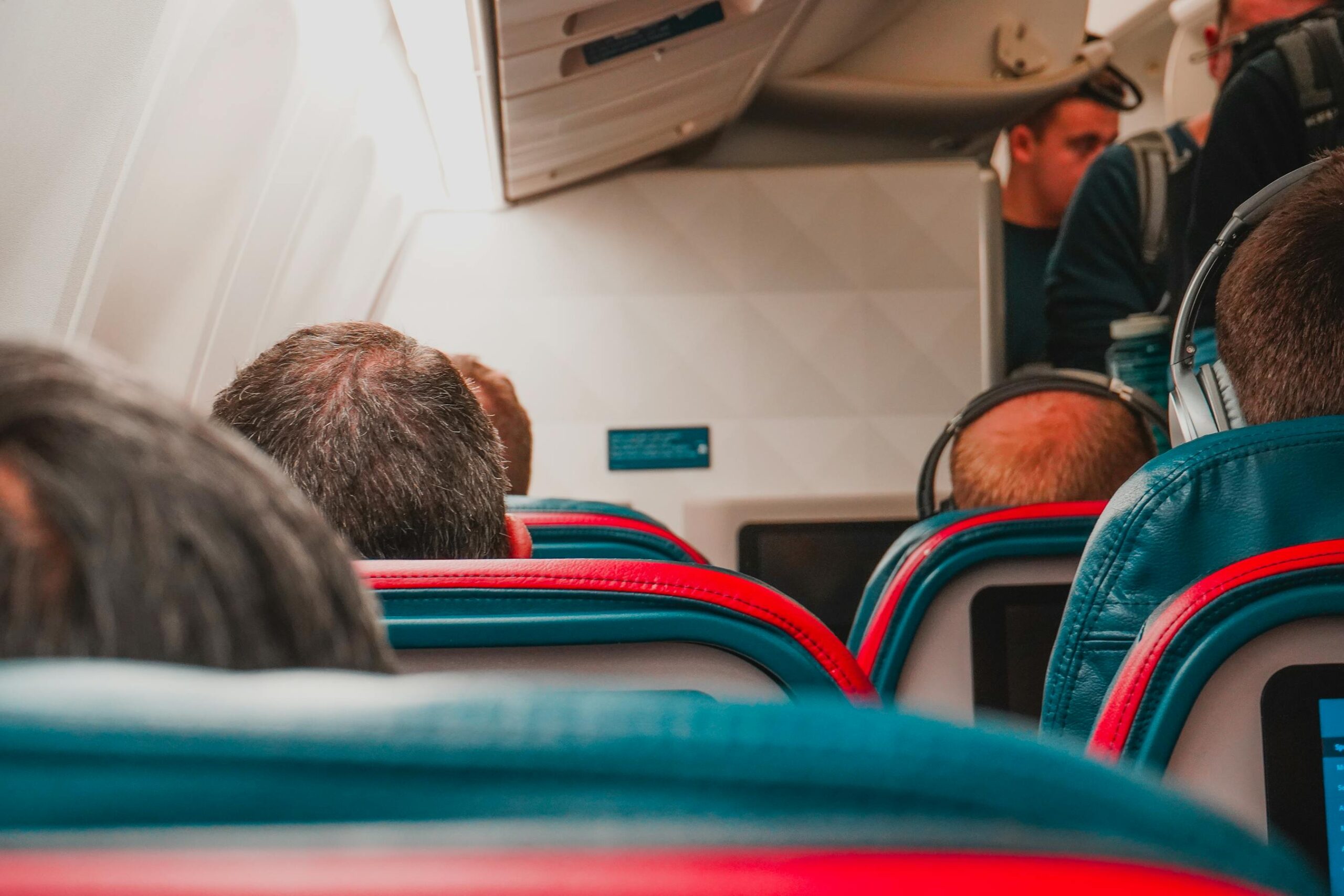 Volar siendo bajito en 2026: trucos para que los pies no queden colgando en vuelos largos 2 Interior de cabina de avion con pasajeros sentados y poco espacio entre filas