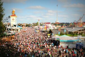 Multitud disfrutando del Oktoberfest en Múnich con carpas cerveceras al fondo