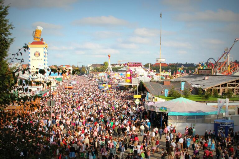 Multitud disfrutando del Oktoberfest en Múnich con carpas cerveceras al fondo