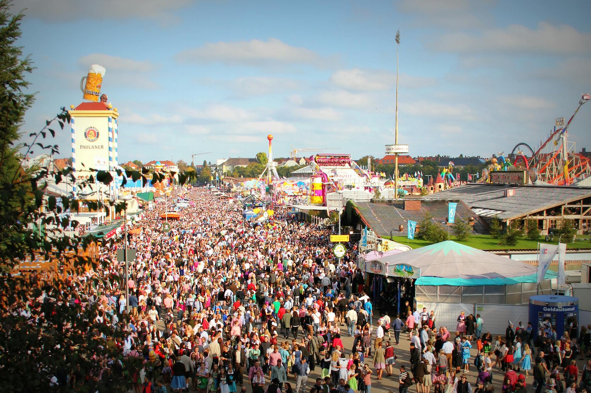 Multitud disfrutando del Oktoberfest en Múnich con carpas cerveceras al fondo
