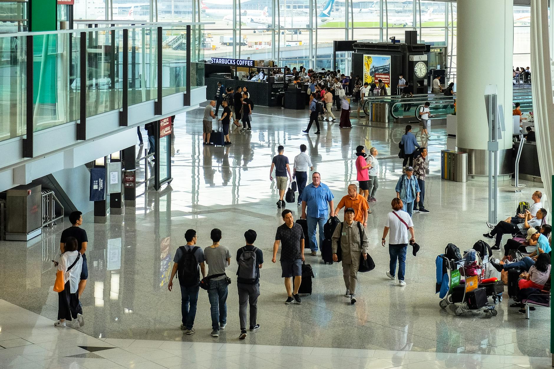 TSA PreCheck y Global Entry en 2026: cómo pasar la seguridad del aeropuerto sin perder el tiempo 1 Pasajeros caminando por un terminal de aeropuerto internacional