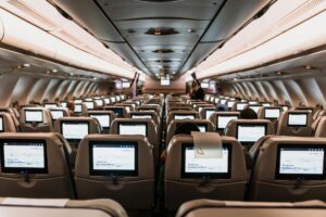 cabina de avión con pantallas de entretenimiento en todos los asientos