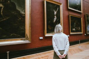 Visitante contemplando obras de arte en un museo, turismo cultural europeo