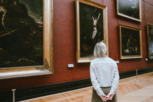 Visitante contemplando obras de arte en un museo, turismo cultural europeo