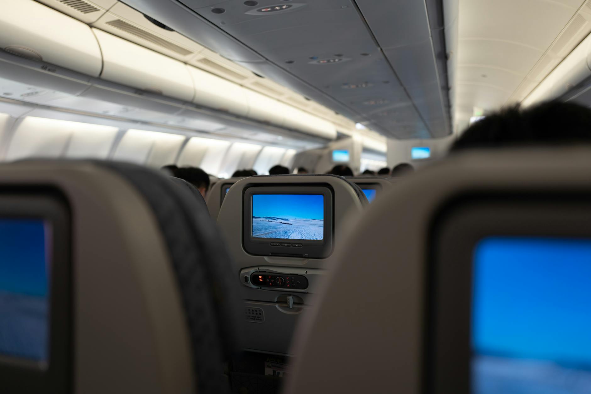 interior del avión con pantallas de entretenimiento a bordo en todos los asientos